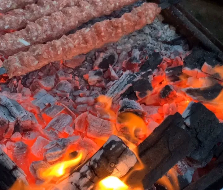 Glowing barbecue coals and flames - showcasing our authentic grilling techniques